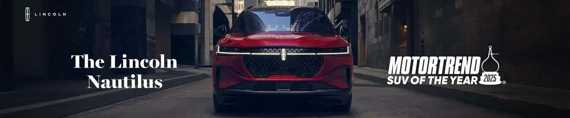 Red Lincoln Nautilus in a city street, with text highlighting it as MotorTrend's 2025 SUV of the Year.