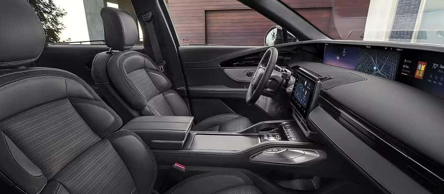 Luxurious car interior with black leather seats, modern dashboard, and digital displays.