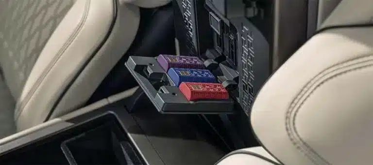 Car seat back panel with three colored storage containers: red, blue, and purple.