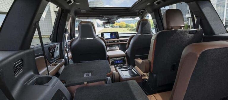 Spacious SUV interior with folding seats, leather upholstery, and modern dashboard display.