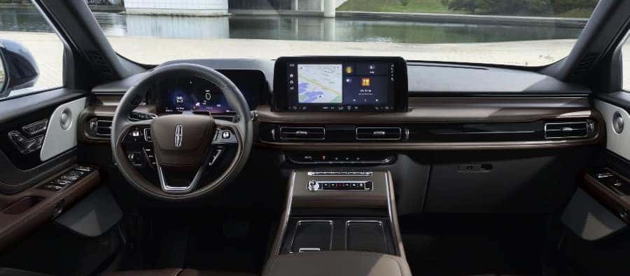 Luxurious car interior featuring a sleek dashboard, digital displays, and a leather steering wheel.
