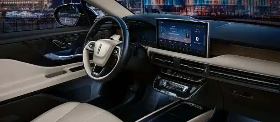 Modern car interior with leather seats, touchscreen display, and sleek dashboard design.
