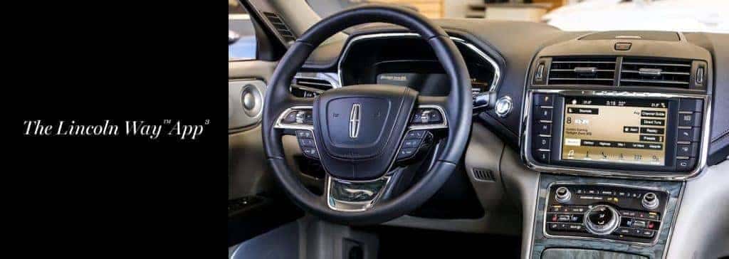 Lincoln car interior showcasing steering wheel and dashboard display with "The Lincoln Way App".