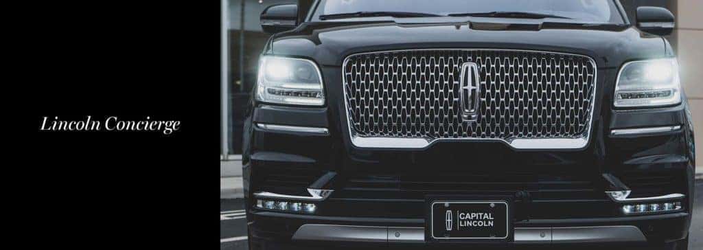 Front view of a black Lincoln SUV with illuminated headlights next to text “Lincoln Concierge.”