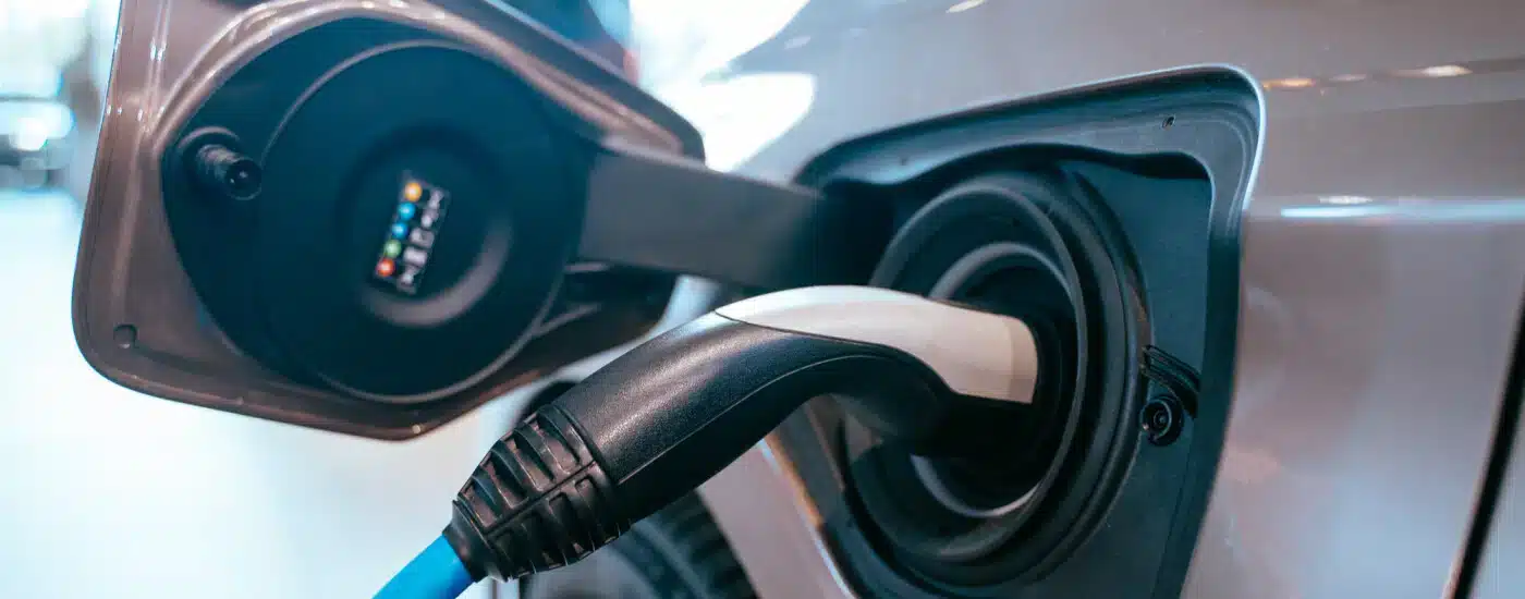 Electric car charging with plug connected to the vehicle's charging port.