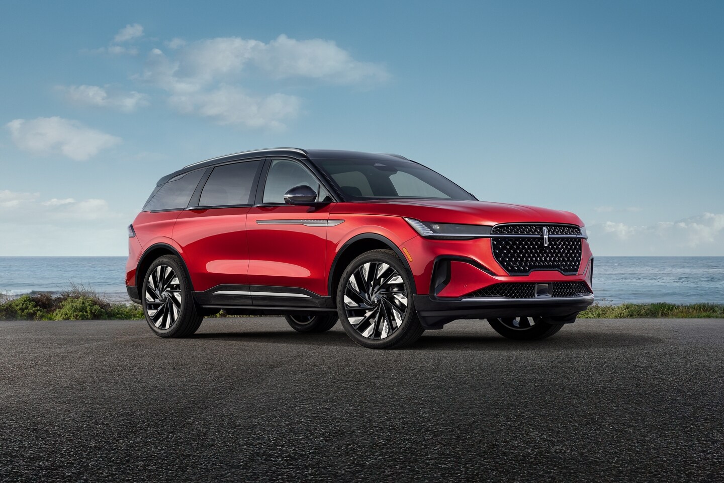A man and woman walking beside a parked dark green SUV in a modern driveway setting.