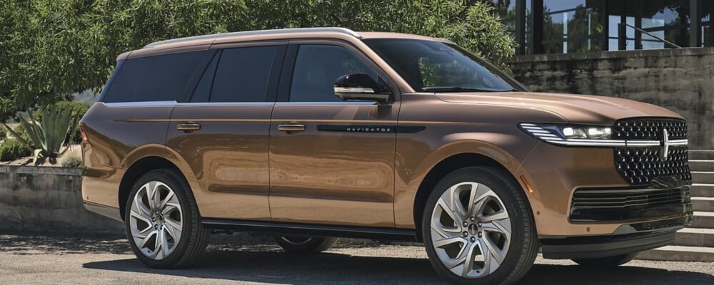 Bronze Lincoln Navigator SUV parked outdoors with a sleek design and large wheels.
