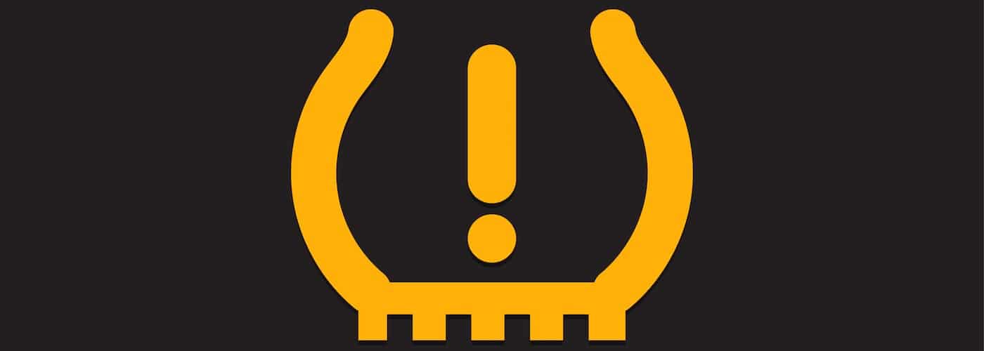 Yellow tire pressure warning light symbol on a black background.